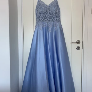 Ljusblå balklänning - Säljer min fina balklänning som endast är testad och sedan använd en gång så mycket fint skick. Den är i storlek 36 men för mig som brukar ha storlek 34 eller 36 var den lite stor. Nypriset inklusive frakten av klänningen är 2787 kr. Föreslå pris!🤍