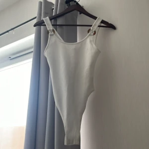 Body - Vit body som är ribbad med en ditalj på banden, väldigt fin med stretch 