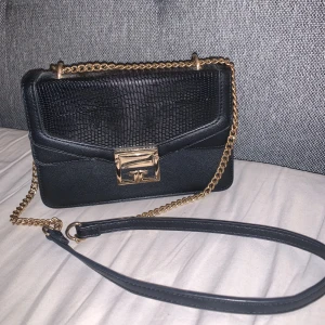 Svart väska - Svart väska med guld kedje band. Väldigt fin men säljer då jag har många andra väskor jag använder mer.