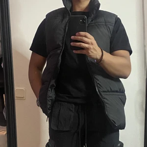 HELT NY Puffer Vest Svart  - Svart puffrig vest från Asos. HELT NY INTE ANVÄND. Storlek S 