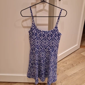 Sommarklänning - Den perfekta enkla sommarklänningen. Blå/vit med vågig kjol och axelband 