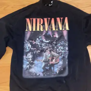 Svart nirvana sweatshirt från hm divided. Med en bild på framsidan och text på baksidan.