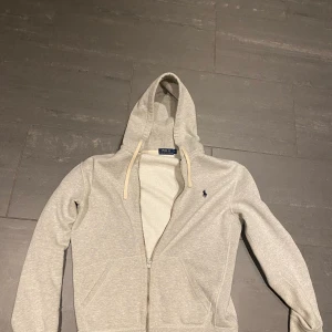 Ralph lauren polo  - Säljer en raulp lauren polo zip hoodie. Använd några gånger men har inga märken eller smuts. Luvan är gjord av ett lite tungre material. Har ett litet hål under armen men svårt att se. Skriv för mer bilder eller info:)