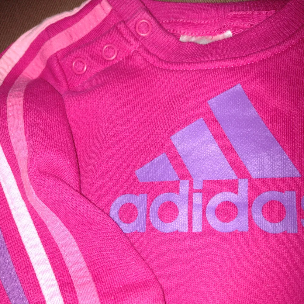 Cerise/rosa tröja/sweatshirt från Adidas. Storlek 68, UK 3-6 mån. Använd bara någon enstaka gång och i så gott som nyskick. 70% bomull och 30% polyester.. Tröjor & Koftor.