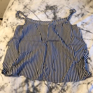 Randig topp - En blåvit randig luftig topp köpt på H&M för 2-3 år sedan. Ej använd, nytt skick.  Frågor?  Skriv i DM  Köparen står för frakten. 