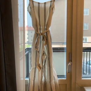 Randig byxdress - Randig byxdress, svår att få på bild då den större (bredare) i benen än vad det ser ut på bild. Snörning i midjan med ett snöre som hänger i små ugglor runt dressen. Dragkedja i nacken. Nypris 1000 Mitt pris 300