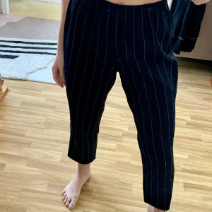 Randiga kostymbyxor m resår i midjan - Väldigt sköna och stilrena byxor! Står M på etiketten men skulle säg den passar både mindre och större storlekar. 