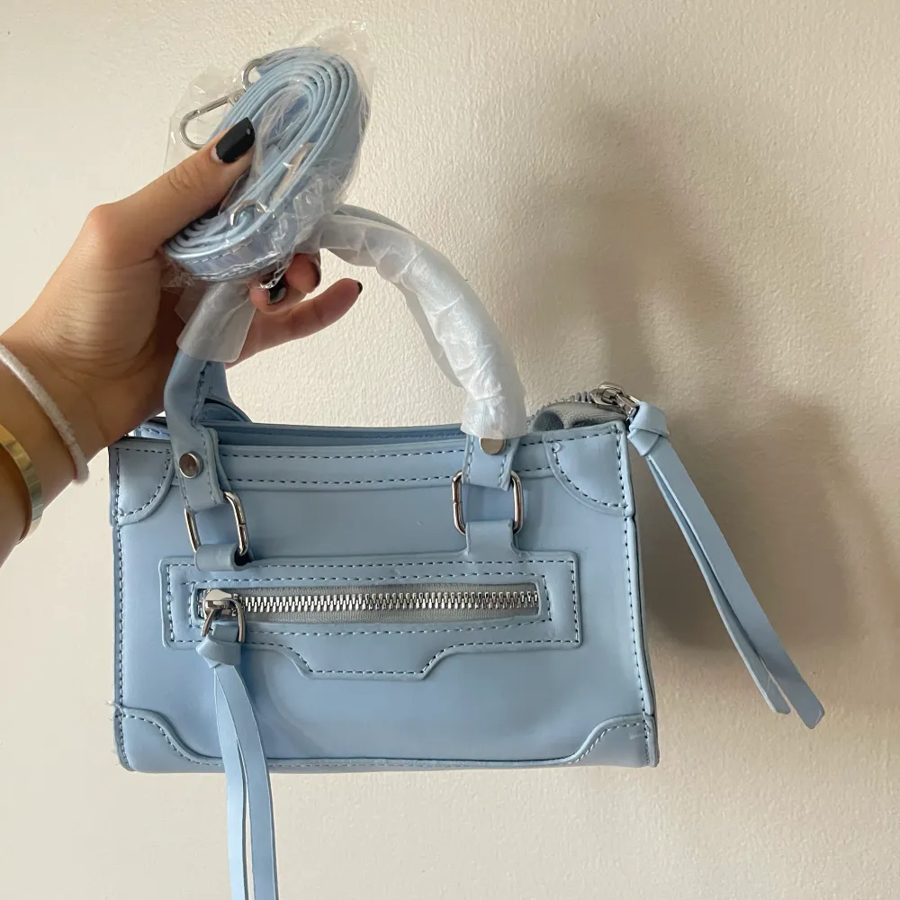Liten ljusblå söt väska ifrån SHEIN, aldrig använd och den har nog legat i min garderob i ett år. Man får också med ett långt band, säljes pga kommer ej till användning. Väskor.