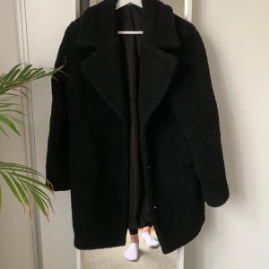 Teddykappa - Svart Teddykappa från Ginatricot, storlek 34. Ena fickan har ett litet hål i sig. 