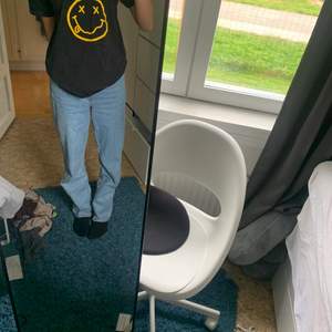 En oversized T-shirt med ett tryck med nirvana text och en smiley med kors ögon. 