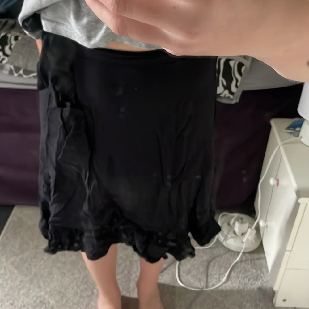 Jag säljer en svart volang kjol som är från Lindex. Den är använd men i bra skick. Den har knytning på sidan.. Kjolar.