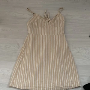 Söt klänning - Söt sommarklänning från hollister med knytdetalj framme vid brösten.  Inte så använd så väldigt fint skick. Stretch i ryggen så den passar även en M.