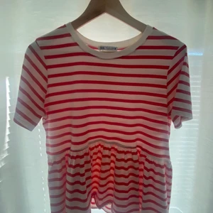Röd vit randig volang zara t-shirt - Säljer denna fina zara t-shirten! Den är knappt använd och den är i väldigt fint skick. Jag säljer då den inte är min stil längre. Storlek S! Köparen står för frakten! Jag kan gå med på att buda ner priset💕💕💝