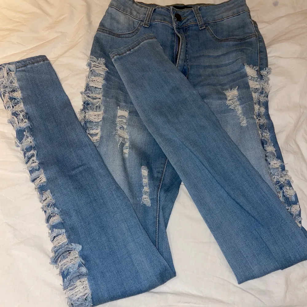 Jeans med slitelse vid sidan av, väldigt strechig och passar allt från xs till M. Figursittande och fint över rumpan. . Jeans & Byxor.