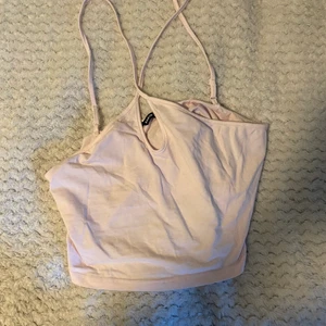 Söt sommartopp - Kort topp i babyrosa!! Går att justera banden. Den är kort och banden korsar i ryggen. 