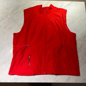 Röd väst - Röd väst i perfekt skick. Säljes pga för stor. Storlek herr 52 men passar nog en kvinna i storlek M-XL som vill ha den lite oversize. 