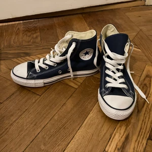 Mörkblå converse Stl 35 - Mörkblå höga converse, storlek EUR 35.   Inköpta i USA ca 2012. (nämner detta pga är osäker på om de nyare ändrat design något).   Är i nyskick då de endast använts inomhus vid ett tillfälle. Säljs pga för liten storlek för mig. 