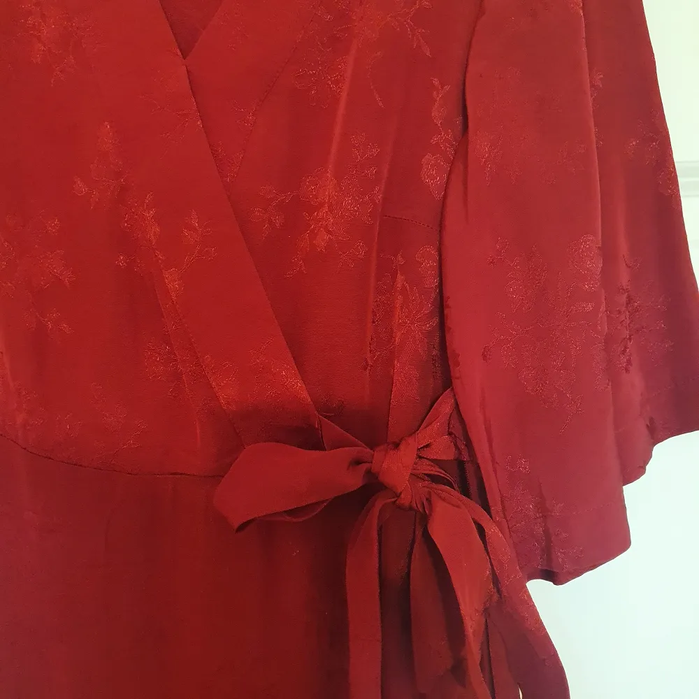 Röd klänning i omlott modell med knytning på sidan.  Köpt på Kappahl,  stl 36. Fint skick, knappt använd. . Klänningar.