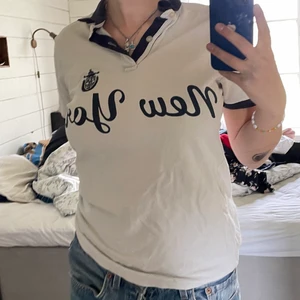 Piké tröja - Skön piké tröja med tryck där det står new york och usa plaggen på ena ärmen. 