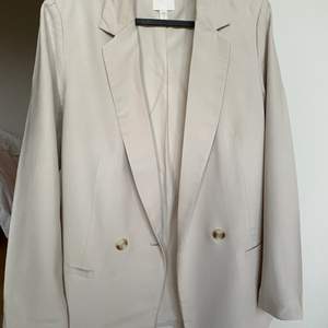 Oversized blazer med axelvaddar i en blek beige nyans. Från H&M i stl. 36. Använd ett fåtal gånger.