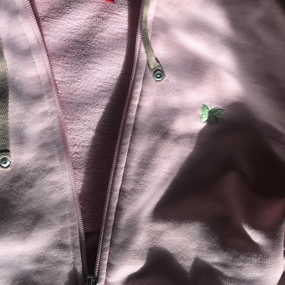 En ljus rosa zip up med en grön fjäril på vänstra bröst. Inga fläckar och helt nopper fri. . Hoodies.