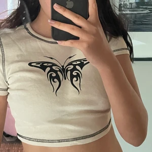 H&M-vit magtröja med tryck - En vit magtröja/topp med tryck på som föreställer en svart, abstrakt fjäril 🦋🖤