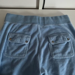 Juicy byxor - Ett par ljusblåa juicy byxor köpta här på plick, men säljer då jag fick ett par nya. Ena juicy grejen på snöret har ramlat av, men annars inga större skador. (Towelling material)