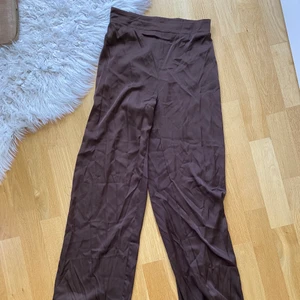 Bruna satin byxor - Bruna satin byxor från BikBok, kvaliteten på byxorna är inte jättebra men de är väldigt sköna.