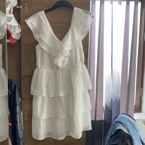 Nelly vit studentklänning  - Säljer denna volang studentklänning ifrån Nelly. Använt 1 gång. I storlek 40