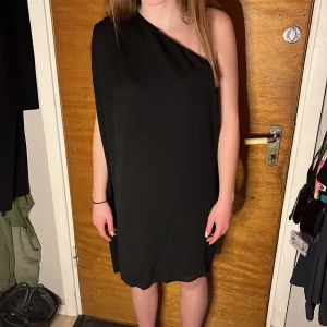 Klänning Acne Studios - Svart klänning jättefint skick. Även fin att bära över byxa. Lagda veck över ena axeln. 