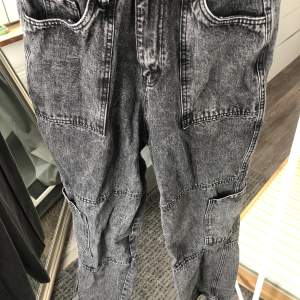 Svarta washed out jeans med både fickor och ett ”handtag”