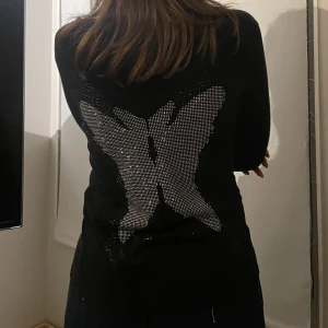 Svart kofta med tryck på ryggen  - Koftan är i mycket bra skick, den är i storlek S men är mycket stretchig så funkar säkert för någon som använder storlek M också 