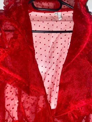 Röd klänning  - Jättefin röd klänning. Den är genomskinlig så skulle rekommendera att ha ett svart linne under!