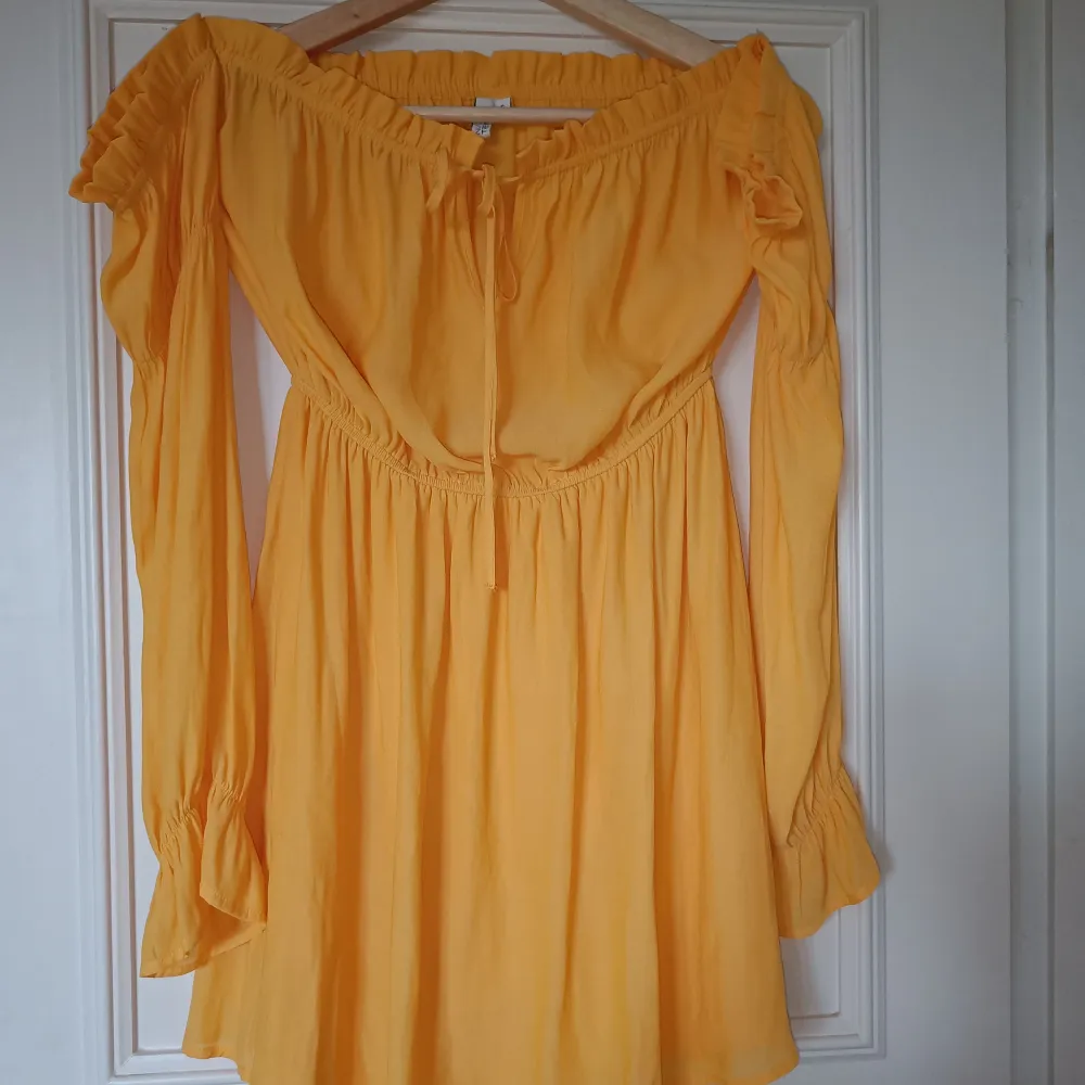 Superfin gul/orange off-shoulder klänning från Nelly. Storlek S. Köpt begagnad men passade tyvärr mig, så säljer den därför vidare. Endast använd 1-2 gånger så är i mycket fint skick!  Så fin till sommaren! ☀️. Klänningar.