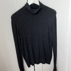 Grå polotröja från Zara  - Grå polotröja från zara med guldiga knappar på ärmarna. 