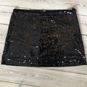 Paljettkjol  - Vårens kanske bästa plagg?? Svart paljettkjol – sexigt SAMT kul! Stylea upp till fest eller med en sliten T-shirt till vardags ⚡️ Saknas några paljetter/slitet i överkanten bak (se sista bilden). Längd: 40 cm. Midja mätt rakt över: 44 cm