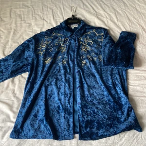 blå sammets skjorta med guld detaljer - En mörkblå sammets skjorta med guld detaljer, älskar den här tröjan men äger inget guld. Inget fel på den! 