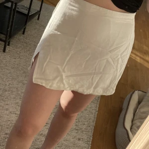 Linnekjol  - Vit kjol i linne med slits på ena sidan. Storlek Small från H&M.
