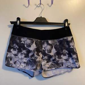 Korta tränings shorts med fint grått blommigt mönster och rosa detaljer. Säljer pga blivit för små i samband med min träning.   Köparen står för frakten 