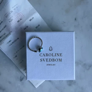 Caroline Svedbom ring - Snygg Caroline Svedbom ring i färgen silver/blå. Den är aldrig andvänd och HELT NY! Perfekt present. Smyckeslåda ingår.  Nypris 395:-