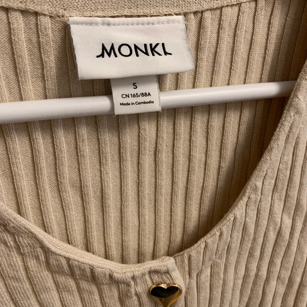 •Beige ribbstickad crop top med guldiga hjärtknappar från Monki •Storlek S •Bra skick •Mitt pris 59 kr. Toppar.