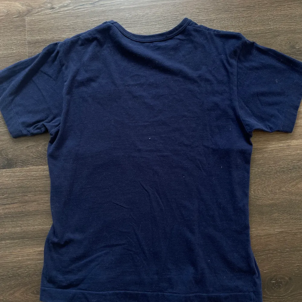 Marinblå T-shirt från play Comme des Garcons. Köpt i London. Kvitto finns. Nyskick  Nypris är 1000kr. T-shirts.