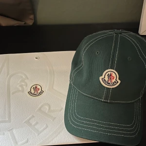 Moncler Baseball Cap - En äkta Moncler keps köpt på Moncler butiken på Birger Jarlsgatan. Nypris 1720kr. Aldrig använd i perfekt skick. Pris kan diskuteras!