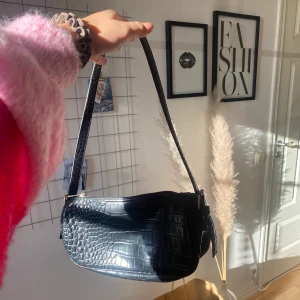 Väska i ”ormskinn” - Säljer denna underbara svarta baguette-bag från Nelly🖤
