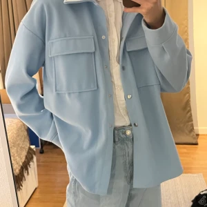 Ljusblå Jacka från Gina Tricot i Strl XL - Ljusblå Jacka från Ginatricot i Strl XL, knappt använd.