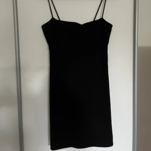 Svart klänning - En svart figursydd klänning med spagettiband. Klänningen kommer från Gina Tricot och är i storlek M. Klänningen är i väldigt gott skick!