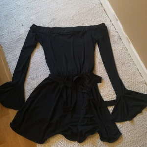 Trumpetärmad playsuit  - Fin offshoulder playsuit med knytdetalj i midja. Aldrig använd. Storlek M