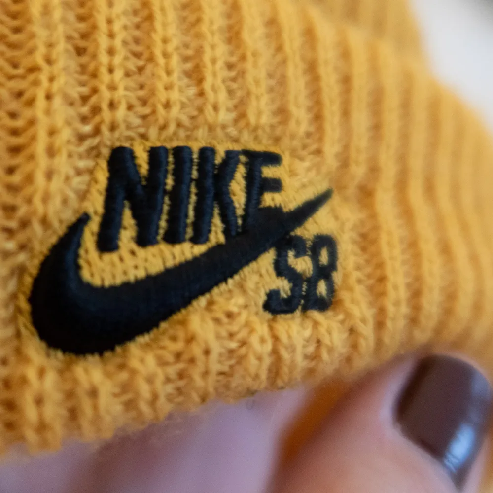 Stickad mössa från Nike i färgen senapsgul. . Övrigt.