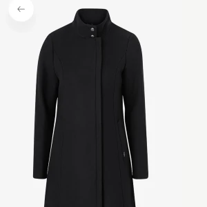 Jofama strl 36. Kostar 2700 kr i butik. - Kappa Emily 2 från Jofama. Figursydd modell med längsgående sömmar fram och bak samt dold dragkedja vid ena sidan. Hög krage med två tryckknappar fram och två infällda fickor med påsydd kant samt en innerficka med dragkedja. Litet sprund med tryckknapp i 