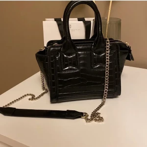 svart zara väska - säljer denna fina väska då den inte kommer till användning. är köpt från sara men slutsåld sedan lång tid. skriv privat för fler bilder mått osv. 